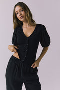 Chaser Abbie Black Blouse in a mid shot highlighting the button front and puff sleeves