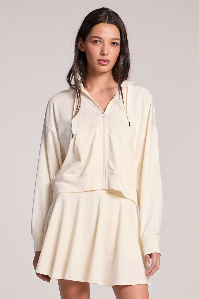 Front view of a woman wearing the Chaser Coconut Milk Abilena on a neutral background, with one hip cocked