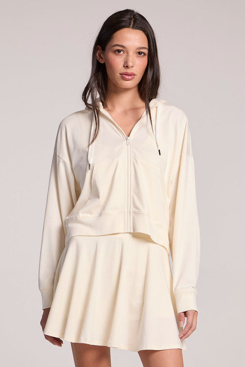 Front view of a woman wearing the Chaser Coconut Milk Abilena on a neutral background, with one hip cocked