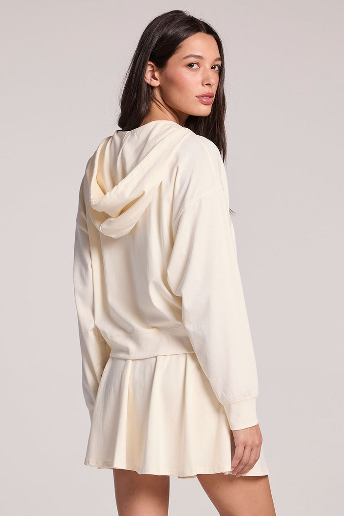 Back view of a woman wearing the Chaser Coconut Milk Abilena on a neutral background, looking over one shoulder