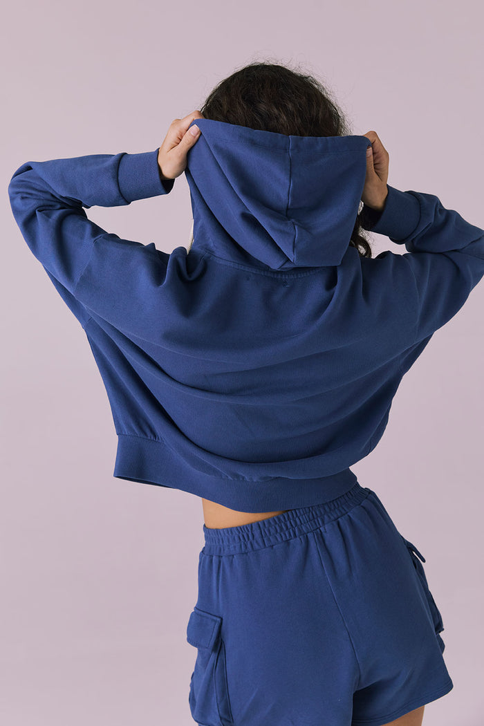 Back view of the Chaser Abilene Honest Indigo Zip Up Hoodie with hood up highlighting the attached hood and smooth fleece texture