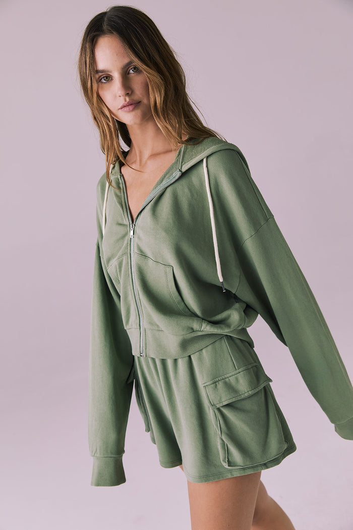 Side view of the Chaser Abilene Meadow Green Zip Up Hoodie highlighting the dropped shoulders and ribbed waistband