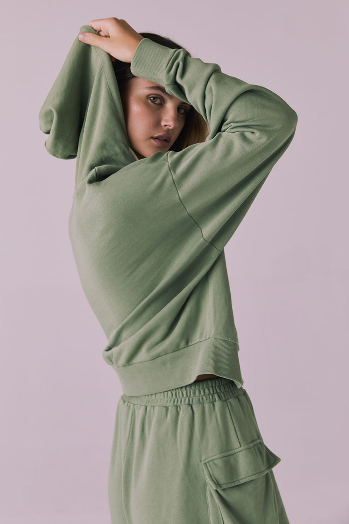Side view of the Chaser Abilene Meadow Green Zip Up Hoodie with hood up highlighting the dropped shoulders and ribbed waistband