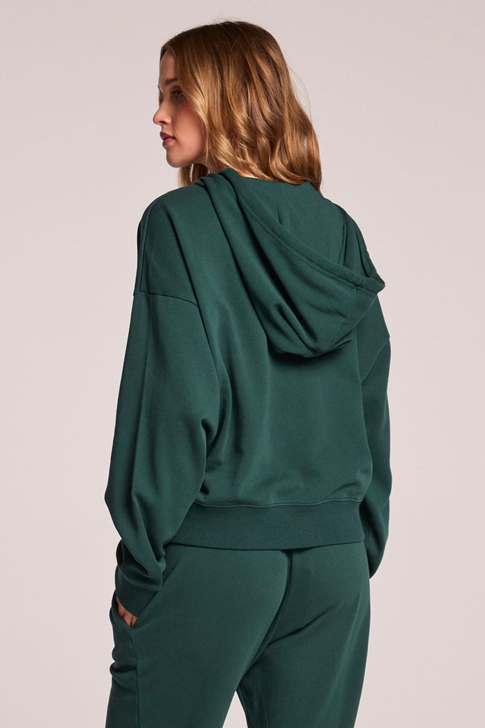 Back view of a woman wearing the Chaser  Abilene Pine Pullover on a neutral background