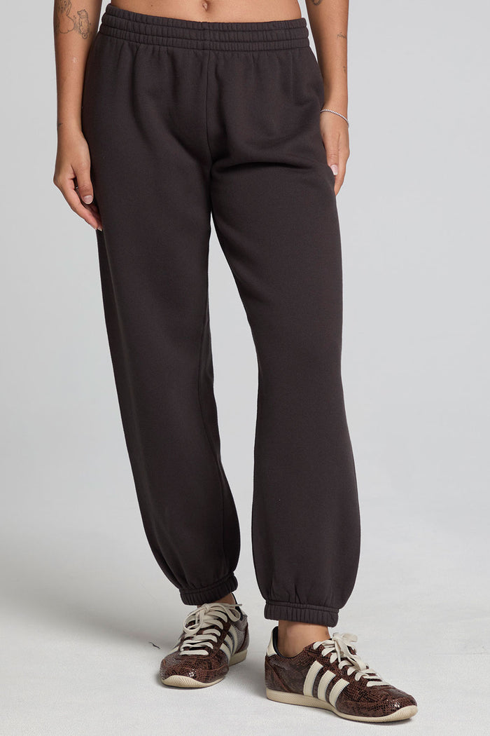 Front view of a woman wearing the Chaser Ada Dark Heather Grey Jogger on a neutral background with sneakers