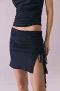 Woman wearing the Chaser Alisha Licorice Black Mini Skirt featuring ruched sides and adjustable drawstring detail