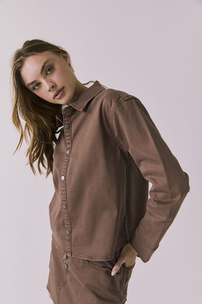 3/4 view of a woman wearing the Chaser brown All Day Cognac Wash Button Down against a plain background