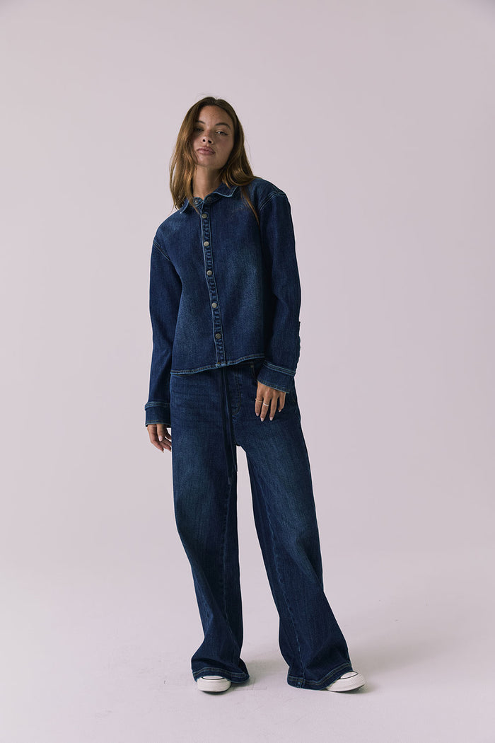 Chaser All Day Indigo Wash Button Down in Indigo Wash captured in a full body studio frame styled with wide leg denim for a relaxed look