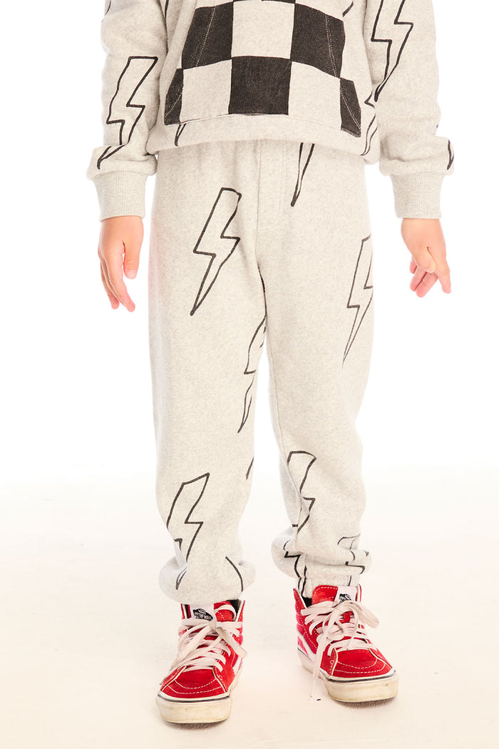 Boy wearing Chaser's gray Allover Bolts pants with lightning bolt designs and on a white background