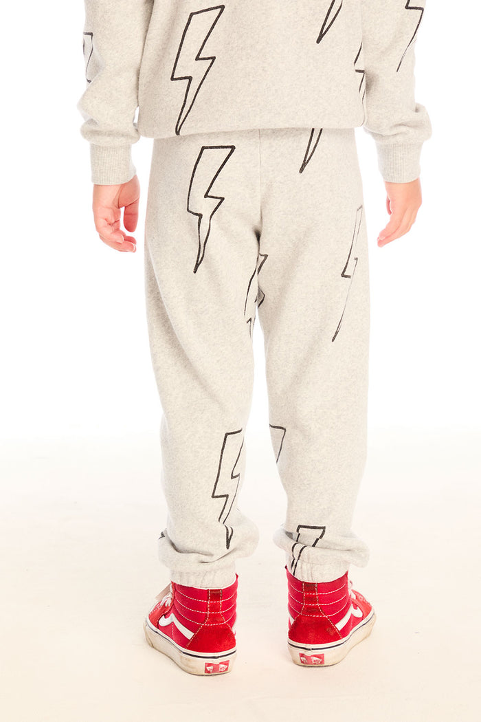 Back view of boy wearing Chaser's gray Allover Bolts pants with lightning bolt designs and on a white background