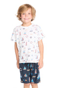 Boy wearing the Chaser Kids Allover Sailboats Tee in white with blue sailboat patterns on a white background