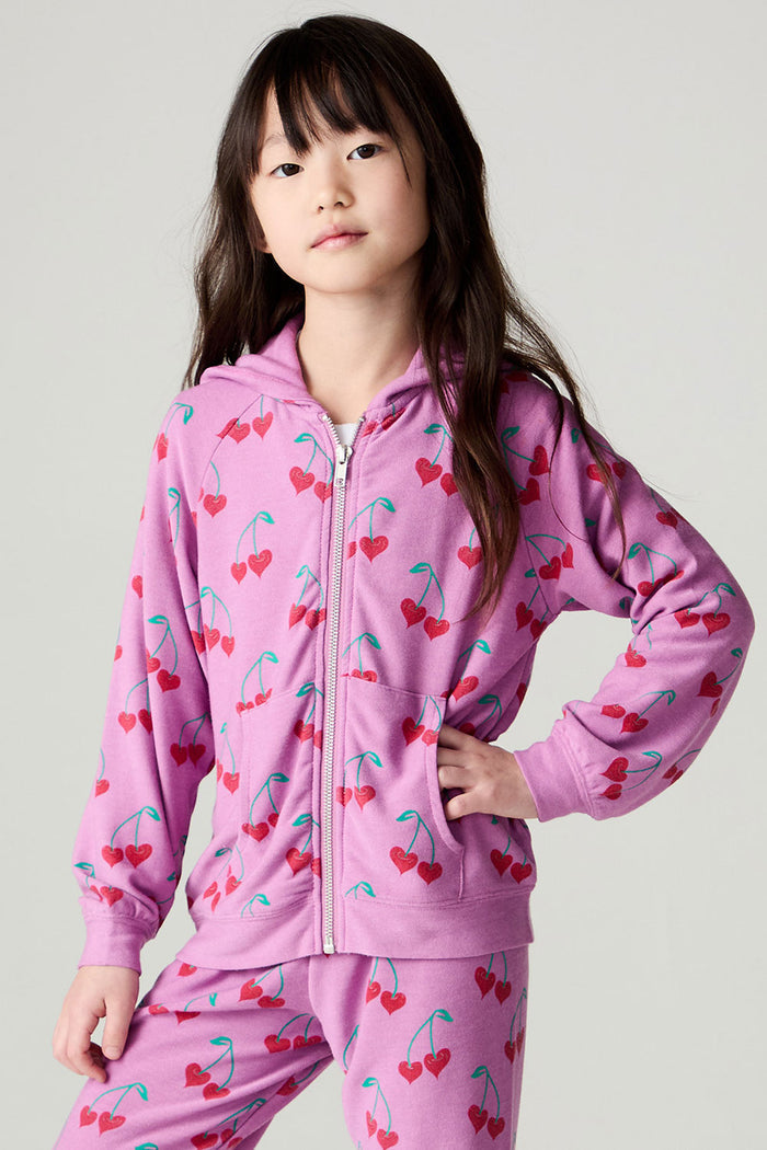 Front view of a girl wearing the Chaser Allover Sweethearts Girls Hoodie on a neutral background with matching pink pants