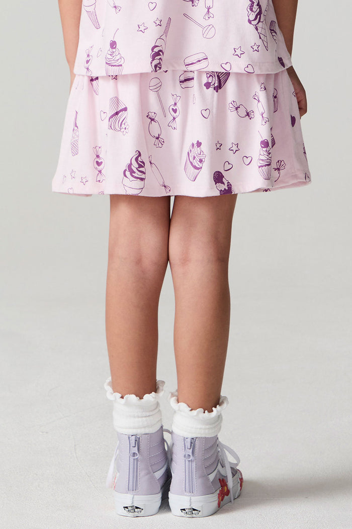 Back view of a girl wearing the Chaser Allover Sweets Peplum Skort  on a neutral background