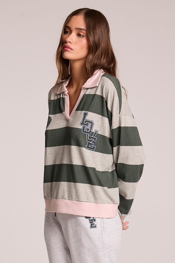 Side angle view of a woman wearing the Chaser Allstar 62  Long Sleeve on a neutral background with hands behind her back