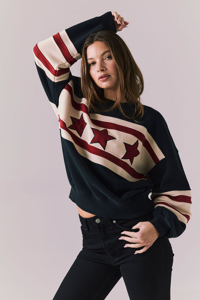 Woman wearing a sweater with star pattern on a plain background