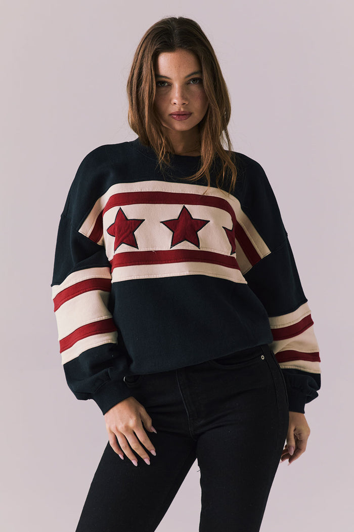 Woman wearing a sweater with star design on a plain background