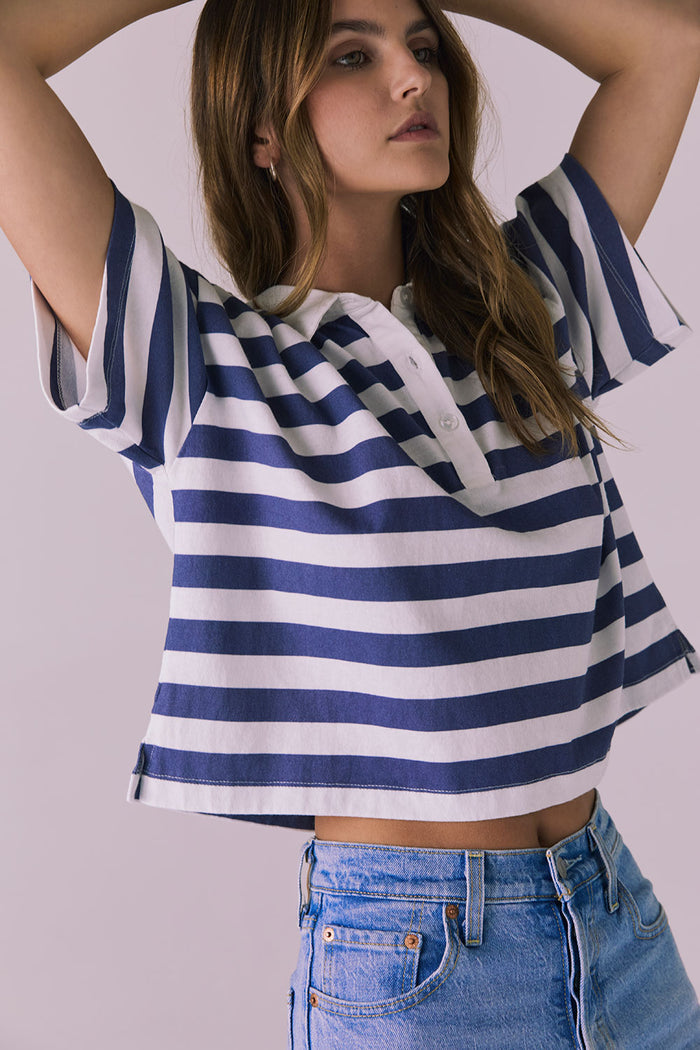 Woman wearing the Chaser Antoni Castaway Stripe Tee featuring wide navy and white stripes with a classic buttoned polo neckline