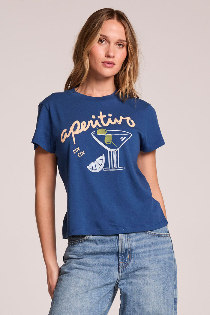 Front view of a woman wearing the Chaser   Aperitivo Tee on a neutral background with one hand behind her back