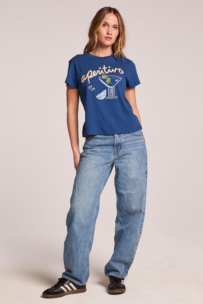 Full body front view of a woman wearing the Chaser   Aperitivo Tee and sneakers on a neutral background