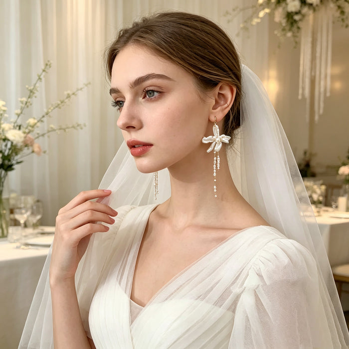 Handmade asymmetrical bridal earrings featuring freshwater baroque pearl flowers, pearl tassels, and 14K gold-filled French hooks.