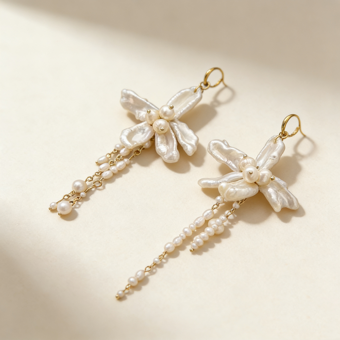 Handmade asymmetrical bridal earrings featuring freshwater baroque pearl flowers, pearl tassels, and 14K gold-filled French hooks.