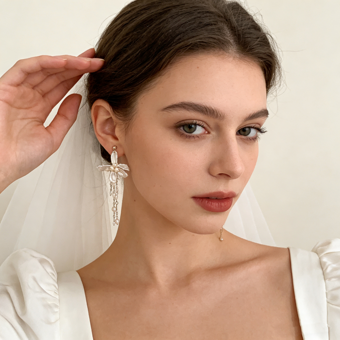 Handmade asymmetrical bridal earrings featuring freshwater baroque pearl flowers, pearl tassels, and 14K gold-filled French hooks.