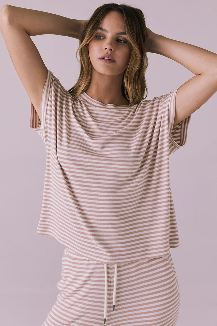 Woman wearing the Chaser Audrey Khaki Stripe Tee featuring narrow khaki and white horizontal stripes with rolled short sleeves