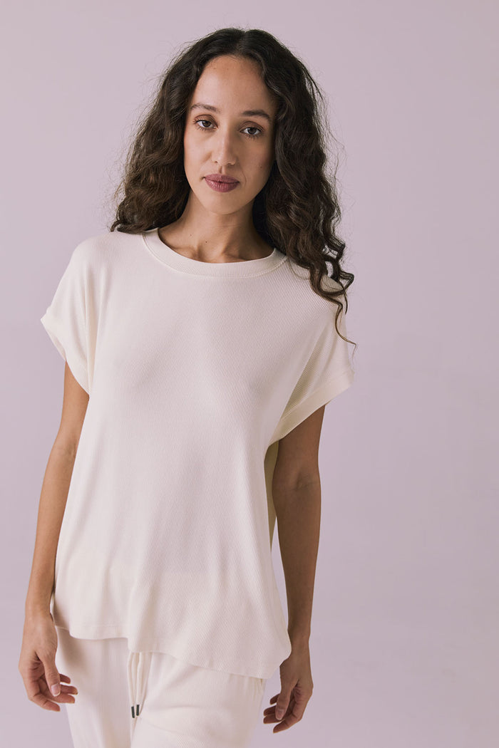 Woman wearing the Chaser Audrey Starry White Tee featuring a relaxed silhouette and rolled short sleeves in soft ribbed knit