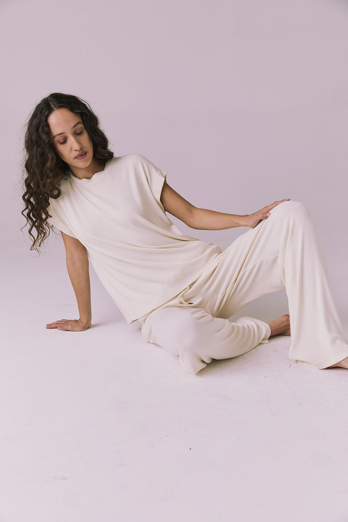 Woman sitting wearing the Chaser Audrey Starry White Tee paired with the matching Sandyy Starry White Trouser in a cozy lounge set