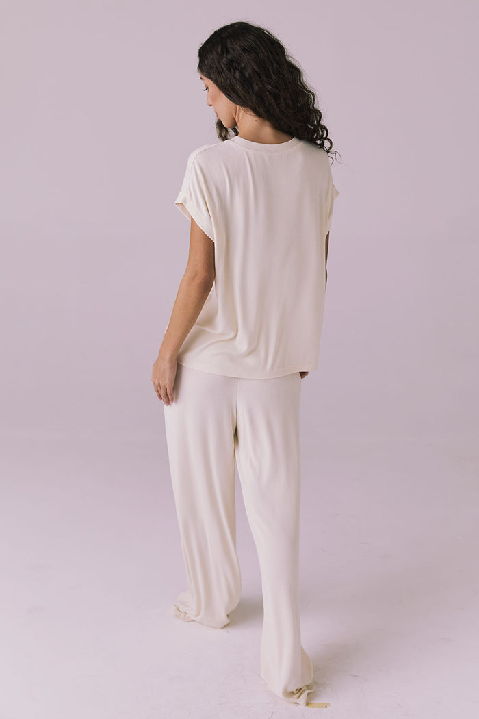 Back view of a woman wearing the Chaser Audrey Starry White Tee paired with the matching Sandyy Starry White Trouser in a cozy lounge set