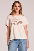 Front view of a woman wearing the Chaser  Avec Le Band Tee and jeans on a neutral background