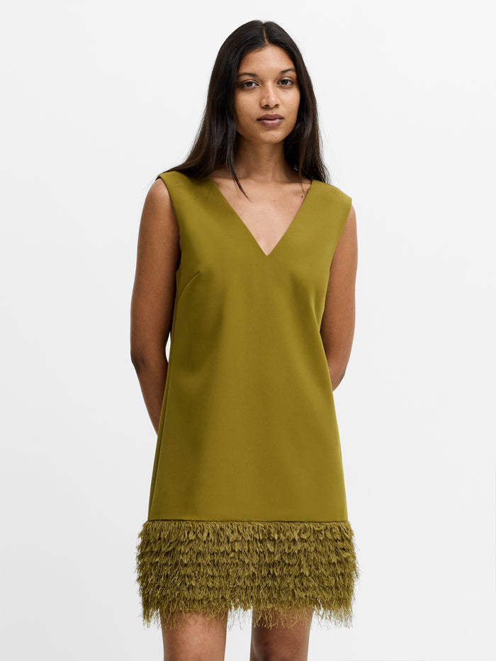 A woman wearing a green sleeveless faux feather trim mini dress with V-neckline and invisible back zip fastening.