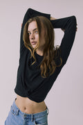Front view of a woman wearing Chaser's Azur Black Long Sleeve top and blue jeans against a plain background