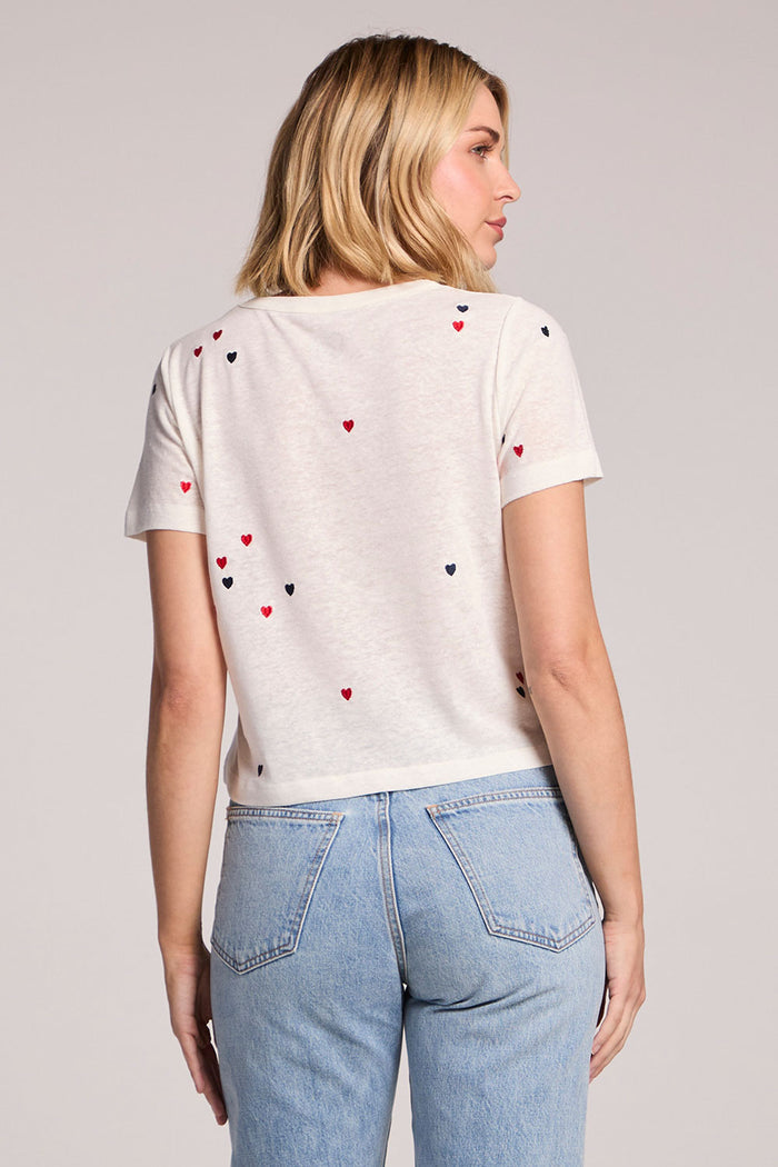 Back view of a woman wearing the Chaser Baby Heart Toss Tee on a neutral background