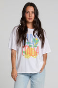 Front view of a woman wearing the Chaser Bagged Italy Tee on a neutral background with blue jeans and hand on waist