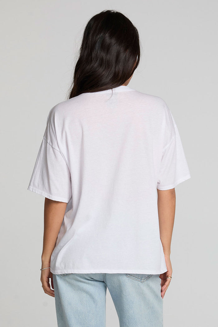 Back view of a woman wearing the Chaser Bagged Italy Tee on a neutral background with jeans