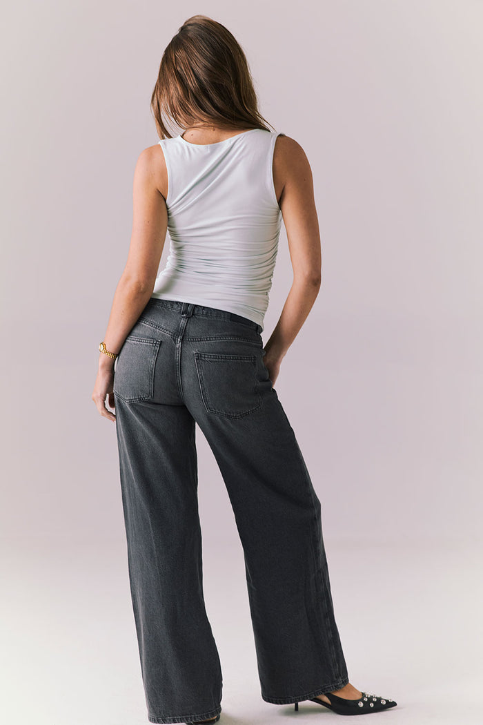 Back view of woman wearing the Chaser Ballad Blue Sweetheart Tank styled casually with denim for a laid-back look
