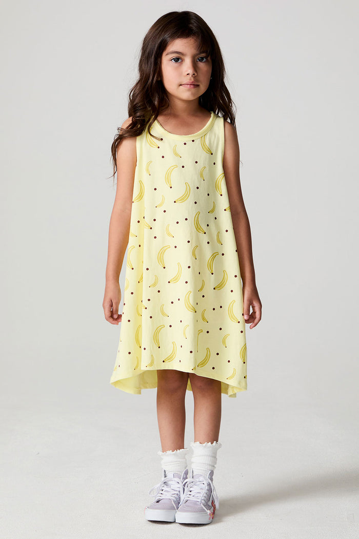 Full body front view of a girl wearing the Chaser Banana Babe Dress and sneakers on a neutral background
