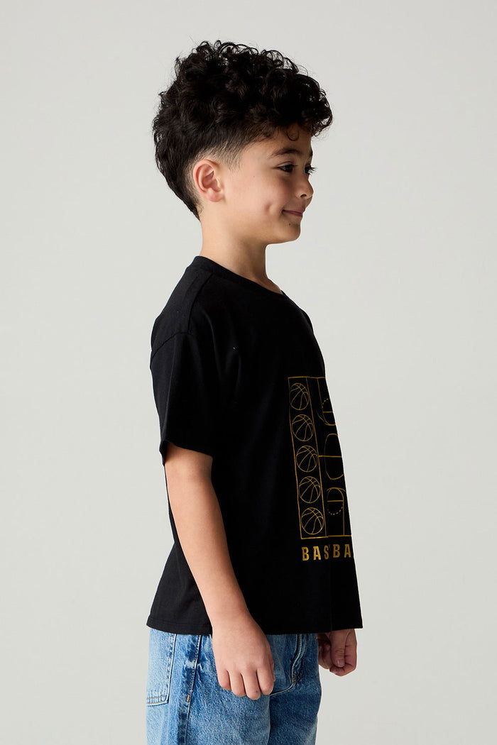 Side view of a boy wearing the Chaser  Basketball Boys Tee on a neutral background and pants