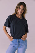 Woman wearing the Chaser Beau Licorice Black Tee featuring a boxy relaxed fit and classic crew neckline