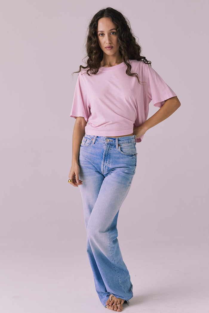 Woman wearing the Chaser Beau Nose Pink Tee styled casually with light-wash denim for a laid-back look