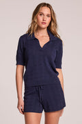 Front view of a woman wearing the Chaser  Bijou Admiral Polo and matching shorts on a neutral background