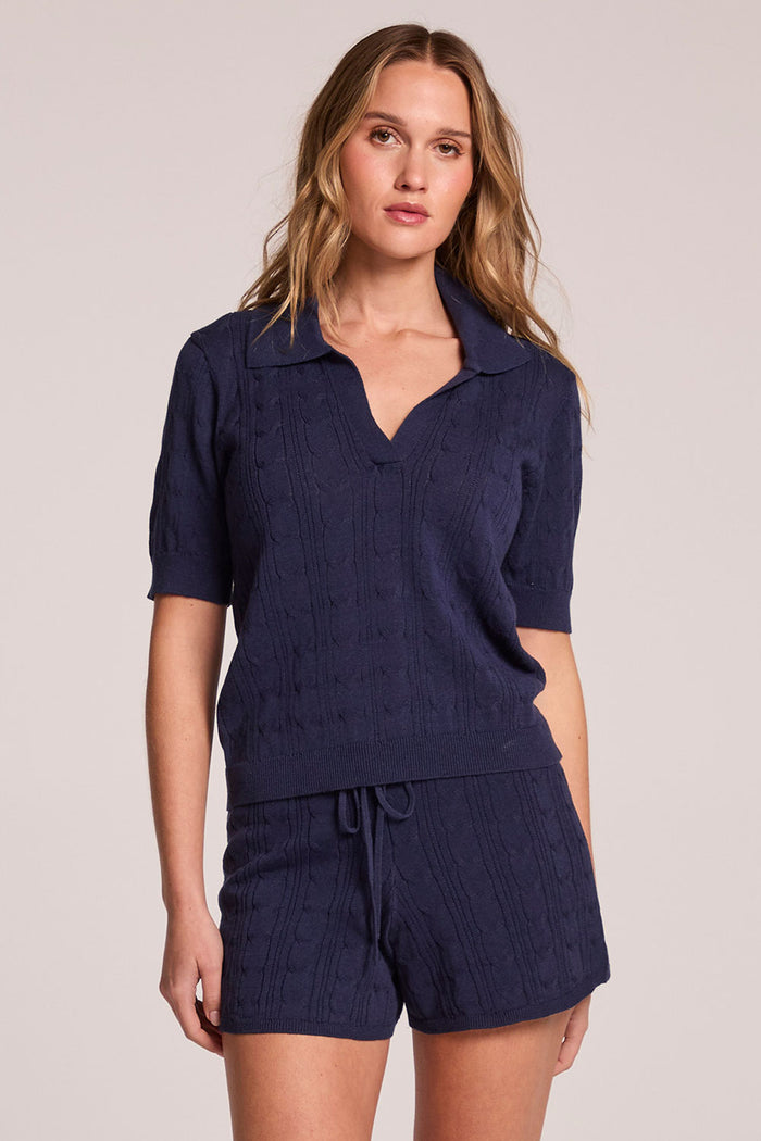 Front view of a woman wearing the Chaser  Bijou Admiral Polo and matching shorts on a neutral background