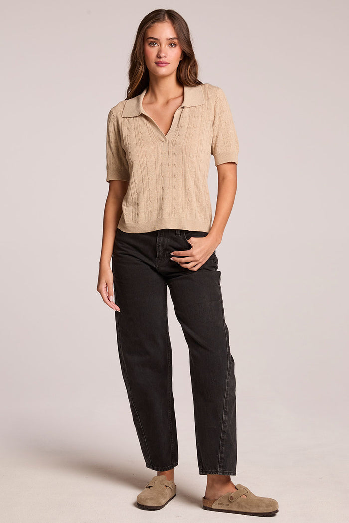 A front view of a woman wearing the Chaser Bijou Khaki Polo and clogs on a neutral background