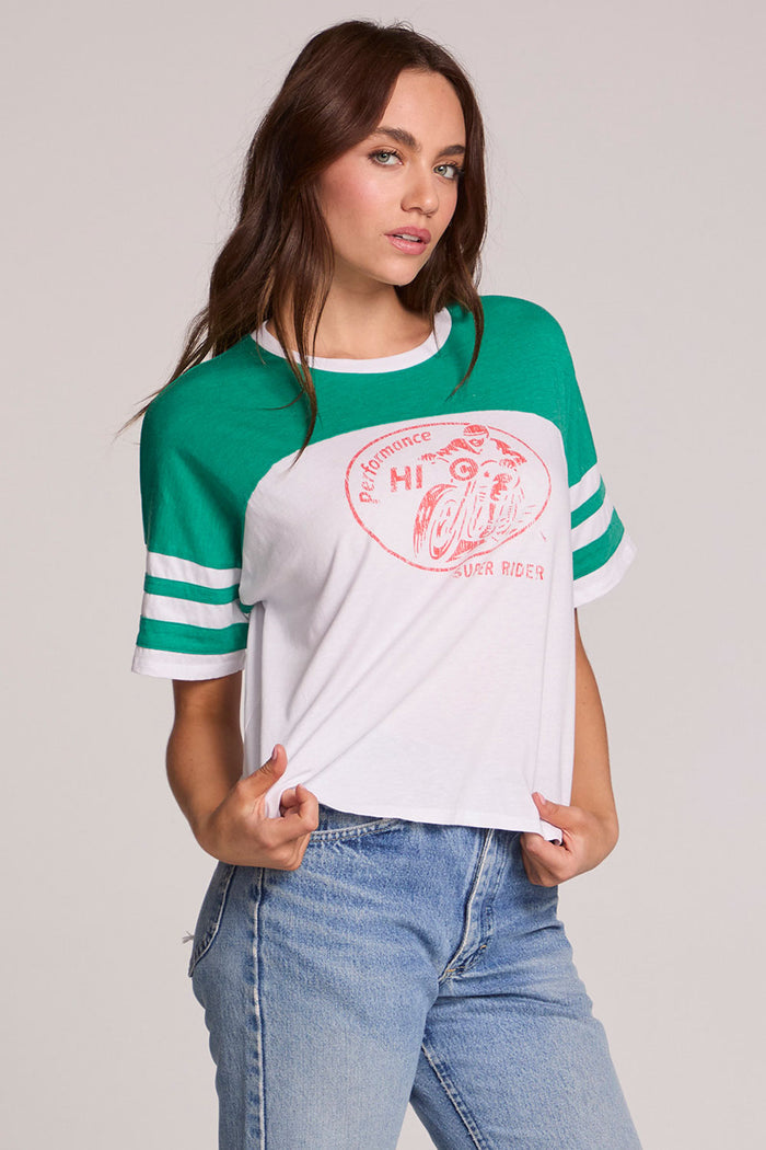 Front view of a woman wearing the Chaser  Biker Rider Graphic Tee on a neutral background with both hands on hem of tee