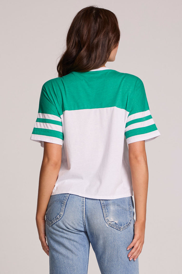 Back view of a woman wearing the Chaser  Biker Rider Graphic Tee on a neutral background with both hands at sides