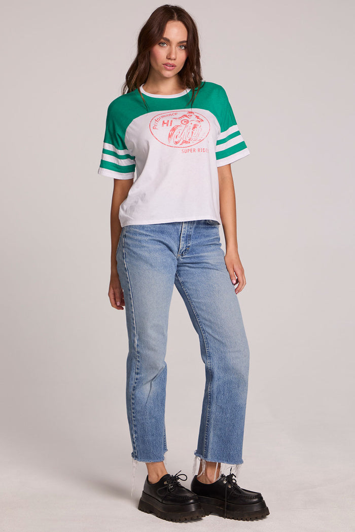 Full body front view of a woman wearing the Chaser  Biker Rider Graphic Tee and blue jeans on a neutral background with both hands at sides