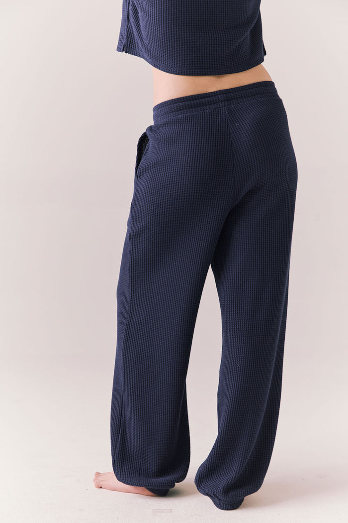 Back view of model wearing Billyy Joggers in midnight blue