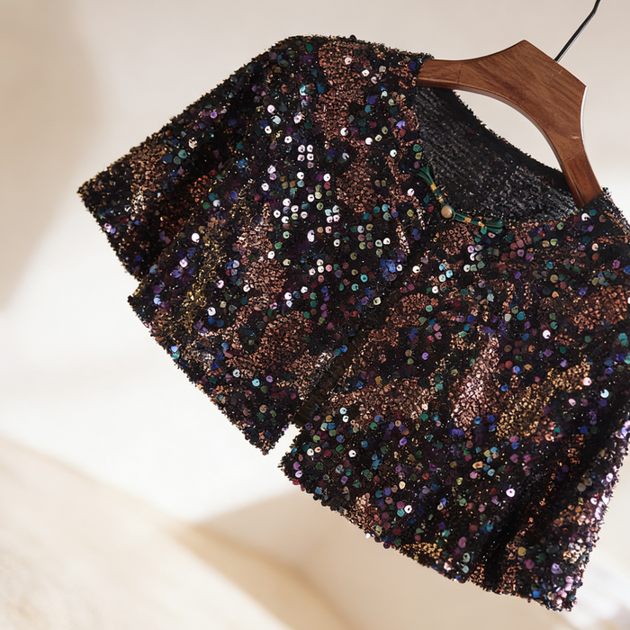 Black iridescent sequin bridal capelet with rainbow sparkle effect, short wedding shawl for evening gowns and formal dresses.