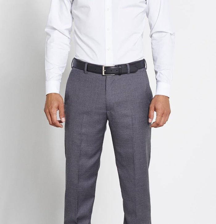 Close-up of a black leather belt worn with grey trousers and a white shirt.
